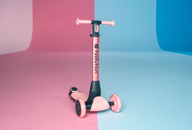 YGlider Nua pink 2‑in‑1 foldable lean‑to‑steer scooter – lightweight kids’ scooter with adjustable arc‑folding handlebar, LED front wheels, wide rear wheel and wall‑mount accessory