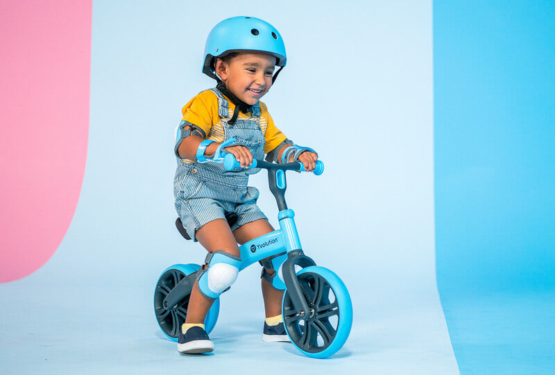 Velo Junior blue balance bike for toddlers – two‑stage no‑pedal training bike with dual rear wheels, adjustable seat and handlebars, lightweight aluminum frame and puncture‑proof wheels