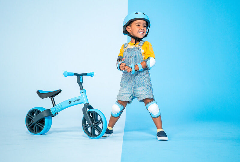 Velo Junior blue balance bike for toddlers – two‑stage no‑pedal training bike with dual rear wheels, adjustable seat and handlebars, lightweight aluminum frame and puncture‑proof wheels