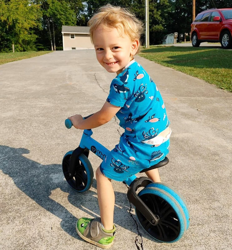 Velo Junior blue balance bike for toddlers – two‑stage no‑pedal training bike with dual rear wheels, adjustable seat and handlebars, lightweight aluminum frame and puncture‑proof wheels