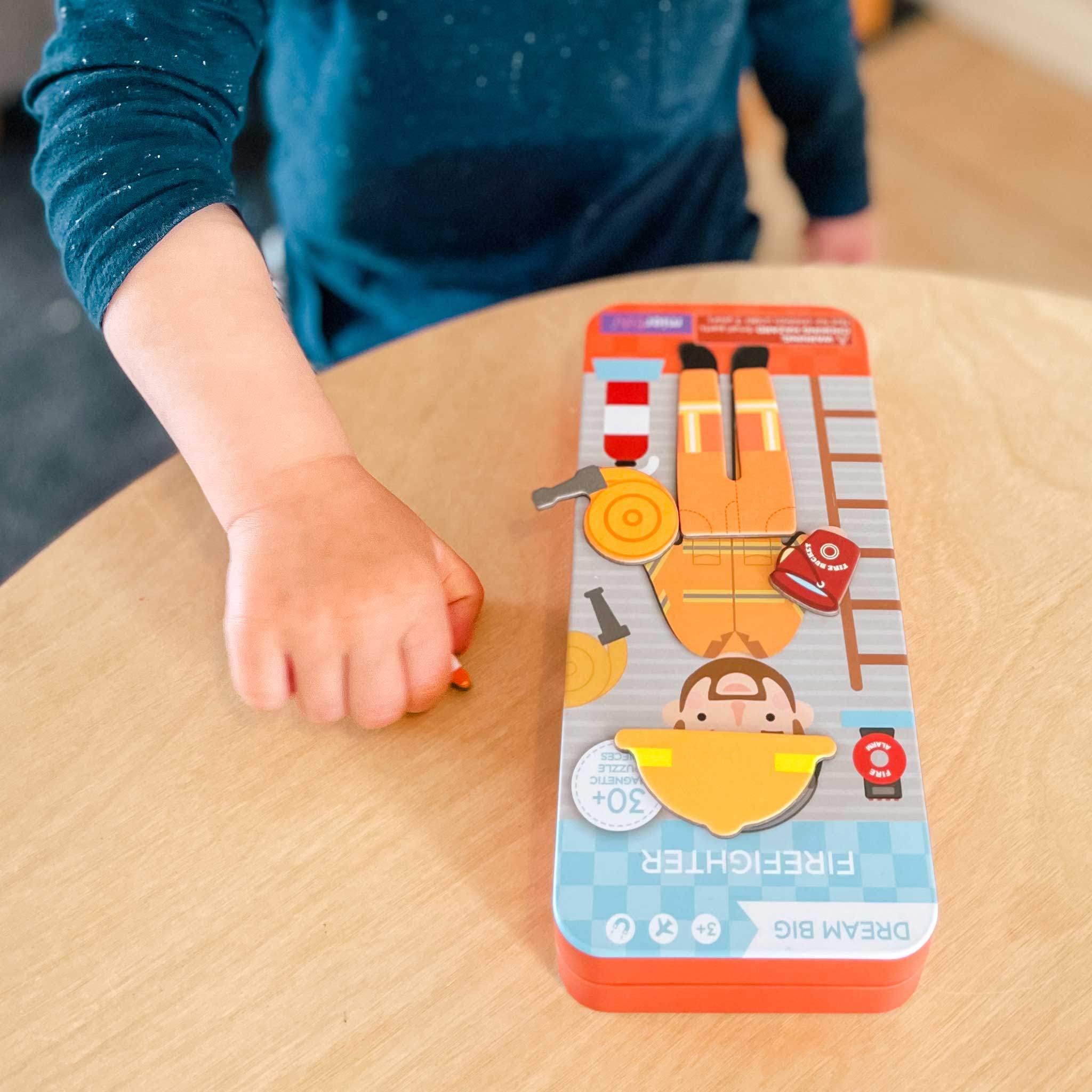 MierEdu Magnetic Puzzle Box – Firefighter edition featuring 32 magnetic dress-up pieces and two illustrated play scenes in a portable tin, perfect for imaginative storytelling and fine motor skill development